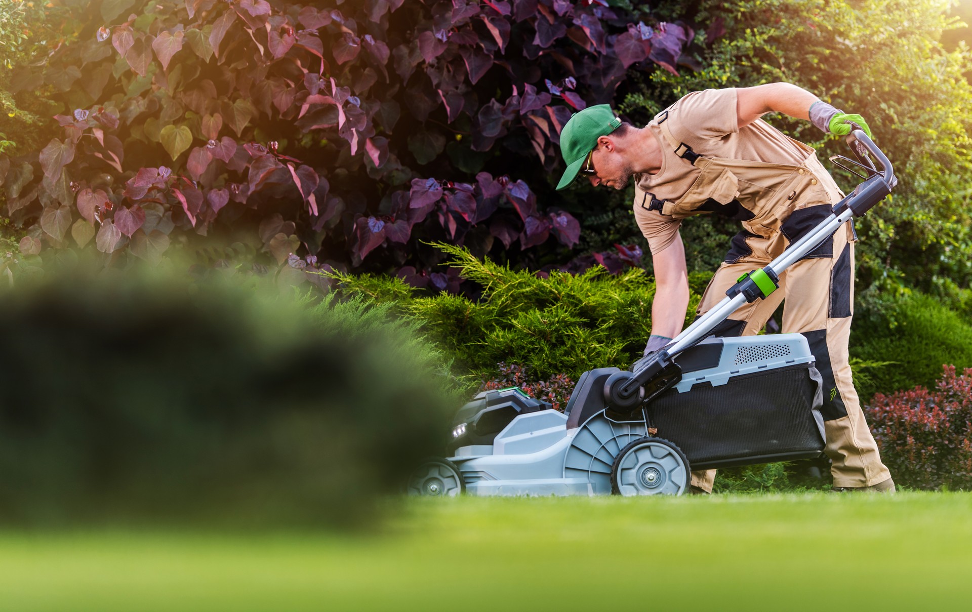 Garden and Landscaping Worker Mowing  Backyard Lawn